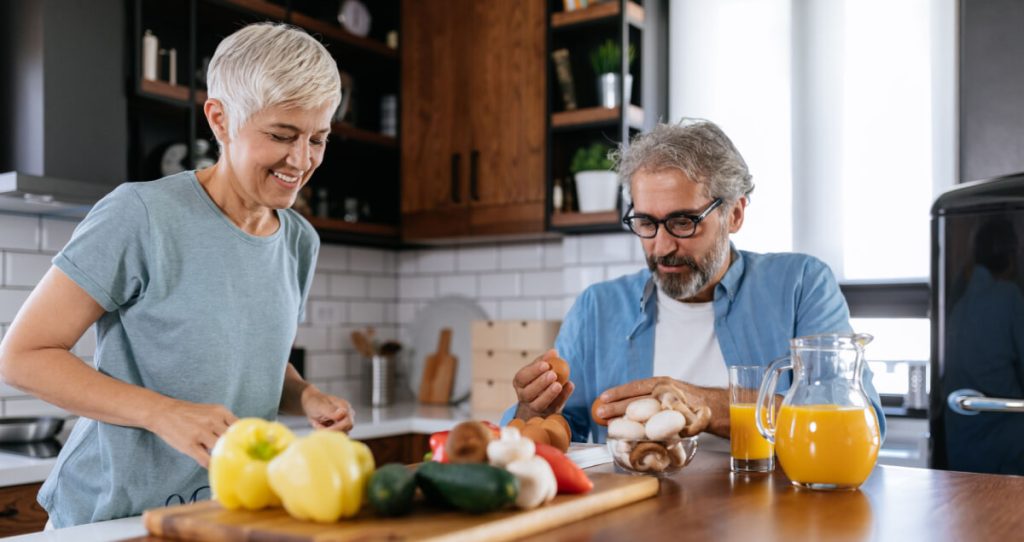 A happy couple making a meal together