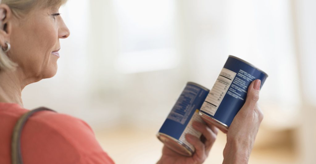 Woman reading labels on a can