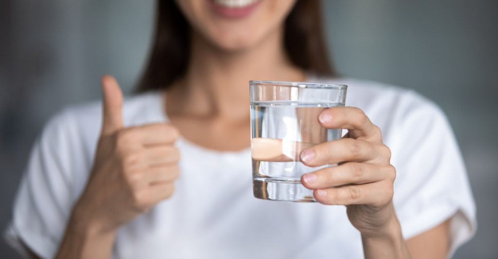 Smiling Woman Holding a Glass of Water