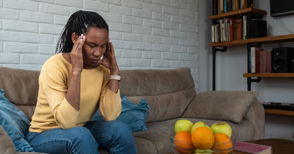 Young woman holding her head in pain