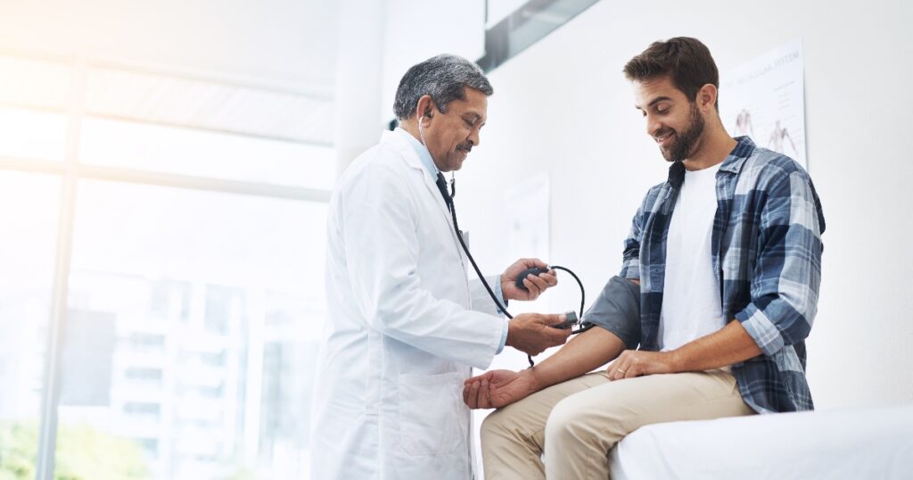 A healthcare professional using a stethoscope to measure a patient's blood pressure manually