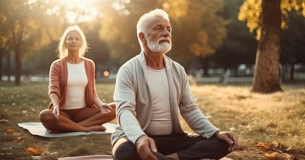 An elderly couple practicing yoga in a serene setting to manage stress and maintain healthy blood pressure