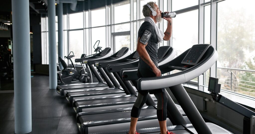 Man on a treadmill drinking a sports drink