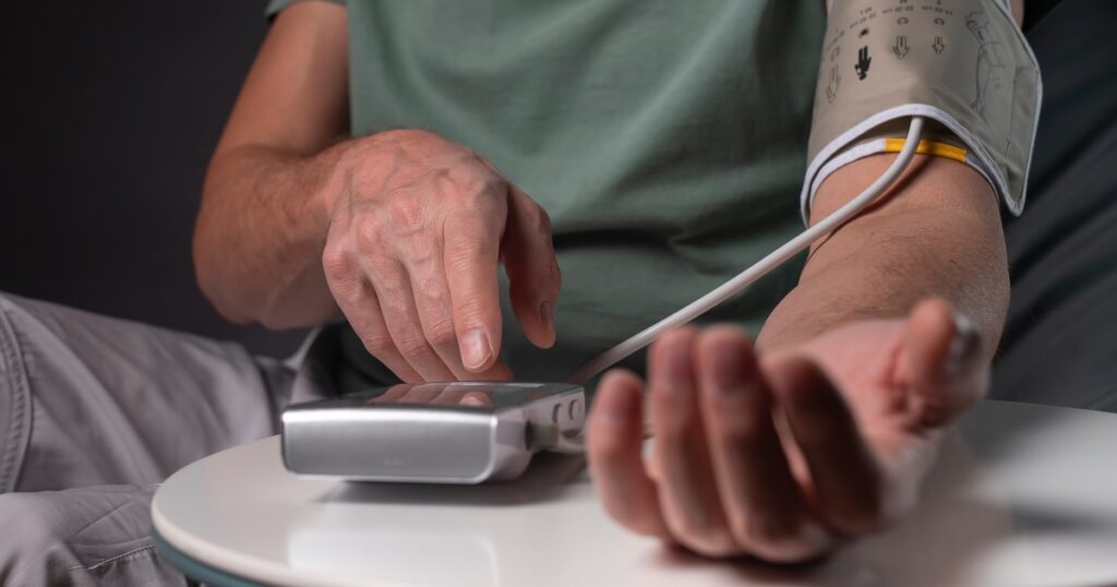Close up of a man measuring his blood pressure in the evening