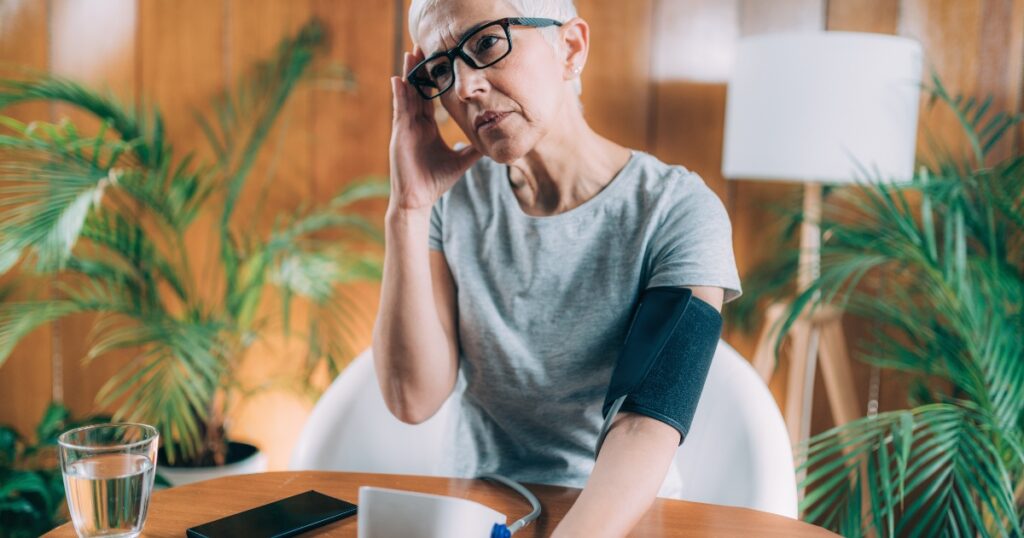 Woman measuring blood pressure and looking worried
